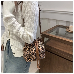 Detailed view of women's leopard print bucket bag with brown drawstring closure