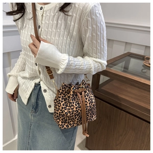 Detailed close-up of leopard print bucket bag with leather drawstring and gold hardware