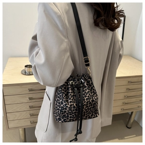 Detail of vintage leopard print bucket bag featuring a drawstring closure and leather strap