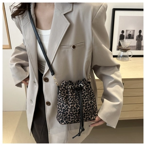Detail of leopard print bucket bag with drawstring closure on a beige blazer outfit