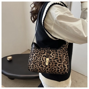 Sac bandoulière tendance à motif léopard avec boucle en métal doré porté par un modèle