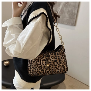 Détail du sac à bandoulière léopard avec chaîne dorée et boucle de fermeture en métal