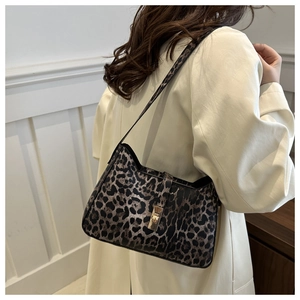 Detail of leopard print shoulder bag featuring gold twist lock and adjustable strap