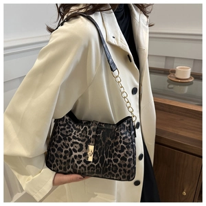 Détail du sac léopard avec bandoulière en chaîne dorée et boucle carrée métallique