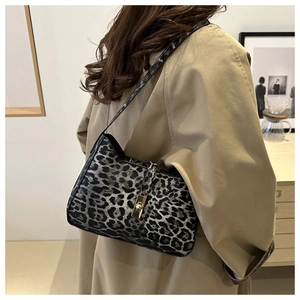 Fashionable leopard print hobo bag with golden lock clasp on woman's shoulder