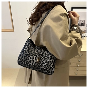 Detail of leopard print handbag with golden twist lock and textured faux fur material