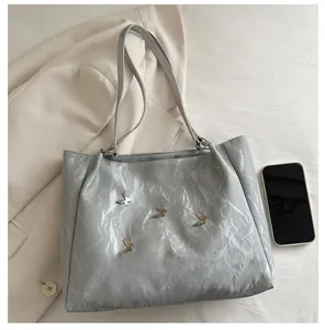 Silver wrinkled leather tote bag with metallic butterfly details and large capacity space