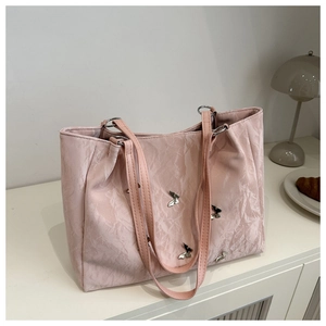 Detail of pink tote bag showing artistic pleat textures and silver butterfly charms
