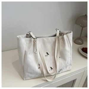 Detailed view of cream tote bag with butterfly accents and unique pleated texture