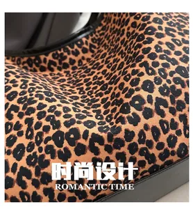 Detailed view of leopard print canvas fabric and premium black leather edge stitching