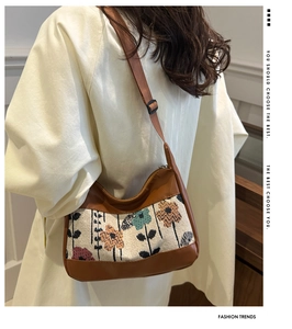 Detail of floral jacquard stitching and brown leather on an elegant shoulder bag