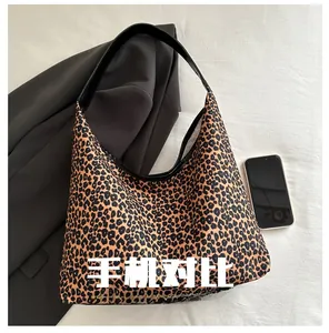 Detailed scale view of a leopard print tote bag next to a smartphone for size reference