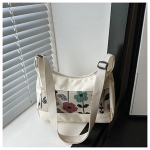 Close-up of white tote bag featuring vintage floral jacquard pattern and adjustable strap