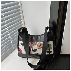 Close-up of retro floral fabric panel on black faux leather shoulder bag texture