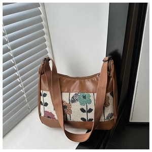 Close-up of vintage floral jacquard tote bag with brown faux leather trim and wide strap