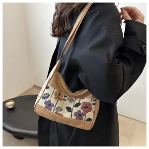 Detail of vintage patchwork hobo bag with floral tapestry and faux leather strap