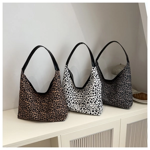 Three leopard print half-moon tote bags in brown, white, and grey with leather straps