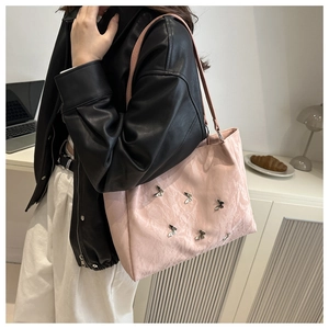 Pink oversized tote bag with butterfly charms and pleated texture shown on model