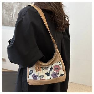 Detail view of khaki shoulder bag featuring floral jacquard panel and wide canvas strap