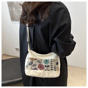 Detail of minimalist tote bag with floral jacquard fabric and cream white leather straps