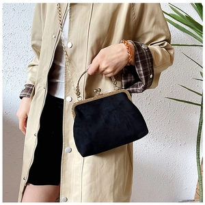 Détail du sac à main vintage en velours noir avec poignée ciselée et chaîne dorée