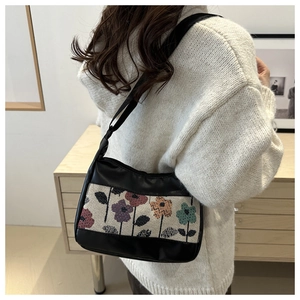 Detail of vintage floral jacquard pattern on black PU leather shoulder bag with shoulder strap