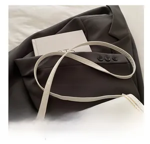Detail of retro small square crossbody bag with contrast stitching and gold metal buckle