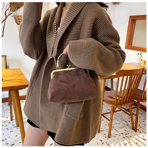 Détail du sac rétro en daim marron avec fermoir doré, perles et bandoulière chaîne