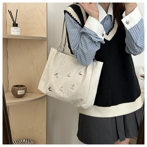 Minimalist white tote bag with silver butterfly charms and slim handles for daily wear