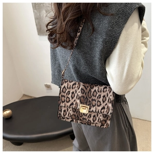 Détail de la texture léopard et du fermoir doré sur un petit sac à bandoulière chic