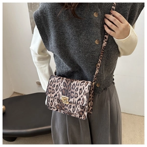 Close-up of leopard print crossbody bag featuring a golden metallic twist lock buckle