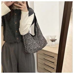 Detail of leopard print hobo bag showing high-capacity canvas design and black edge trim