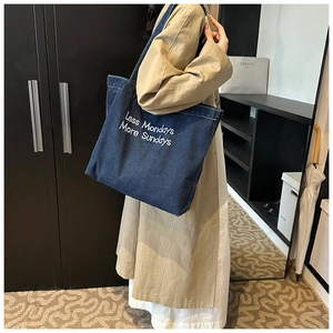 Dettaglio della borsa tote in denim blu con ricamo bianco Less Mondays More Sundays