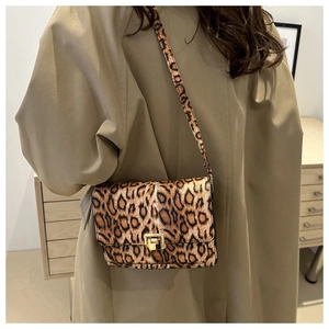 Gros plan du sac léopard avec fermoir doré porté sur un trench-coat kaki élégant