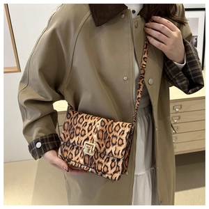 Fashion leopard print crossbody bag with gold buckle shown on a model in autumn outfit