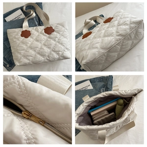 Detailed views of white quilted puffer tote bag with brown flower charm and zipper