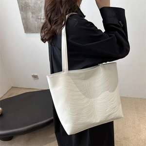 White faux leather tote bag featuring a unique 3D ribcage relief and large capacity