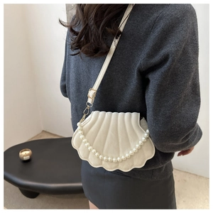 Model wearing white shell bag with pearl handle and stylish wave texture, back view