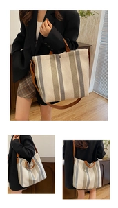 Close-up of canvas tote bag showing striped fabric, leather straps and silver buckle