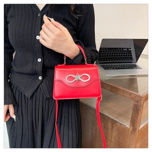 Chic red crossbody bag with crystal bow detail shown with a modern outfit