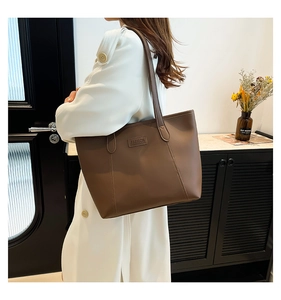 Deep brown oversized tote bag with FASHION label shown on shoulder in modern interior