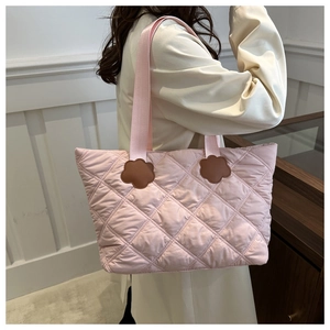 Close-up of quilted pink tote bag featuring unique flower leather patches and soft texture