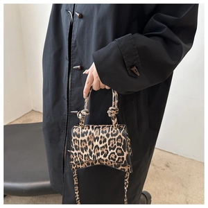 Détail du sac à main imprimé léopard avec poignée nouée et bandoulière longue assortie