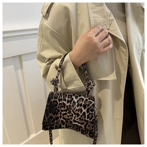 Détail du sac léopard avec poignée nouée et design de base incurvé élégant