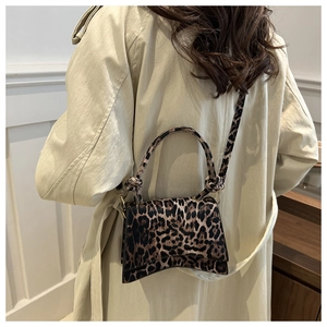 Détail du sac à bandoulière léopard avec base incurvée et poignée nouée élégante