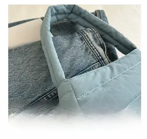 Close-up of light blue quilted nylon shoulder bag with horizontal stitching details