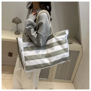 Detail der grau-grünen gestreiften Canvas-Tasche mit naturweißen Seilgriffen