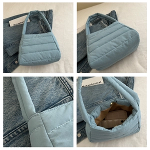 Detailed views of light blue quilted puffer bag showing stitching and magnetic closure