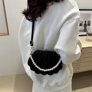 Chic black shell-shaped crossbody bag with pearl chain detail and velvet finish