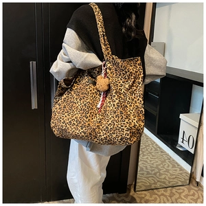 Detail der großen Totebag mit Leopardenmuster und Bärenanhänger getragen am Model